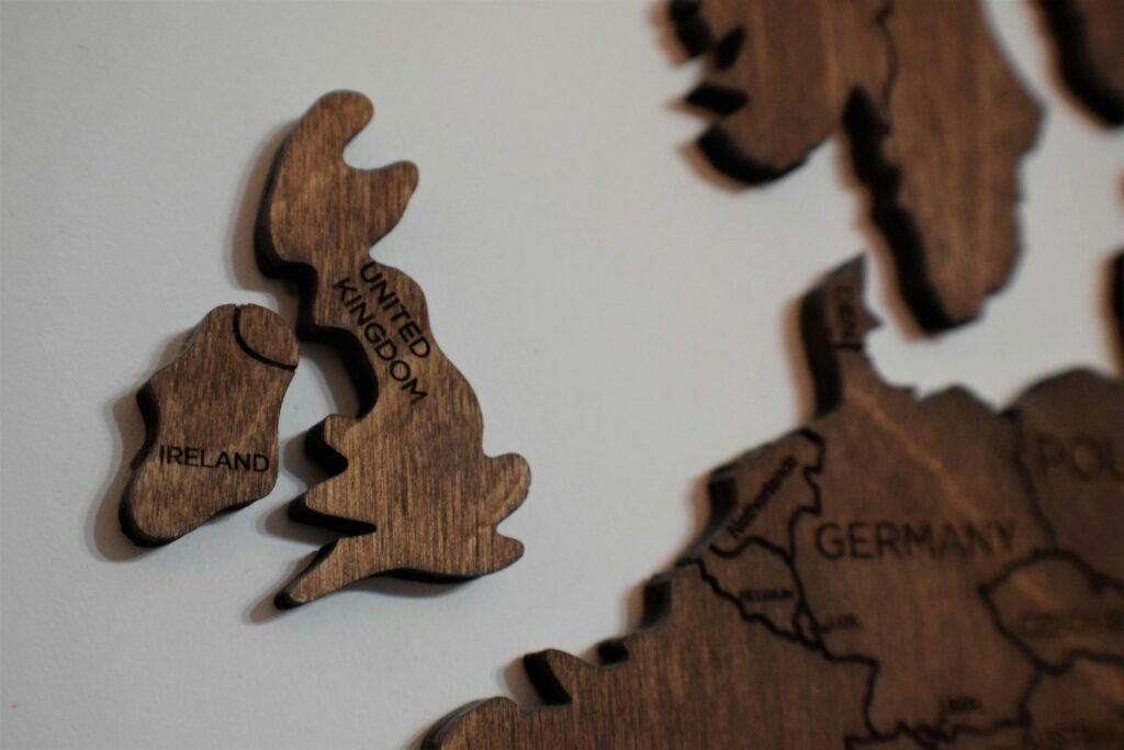Close-up of wooden puzzle pieces shaped like the UK and Ireland on a white background.