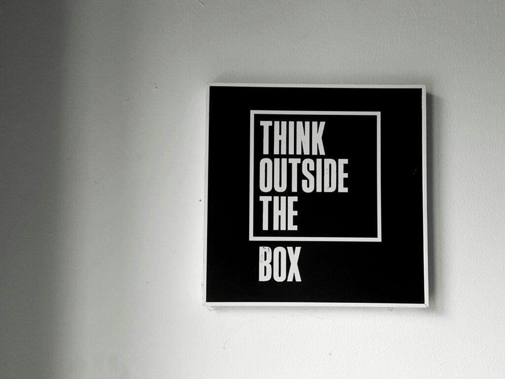 Black and white wall art with 'Think Outside the Box' message for creativity.
