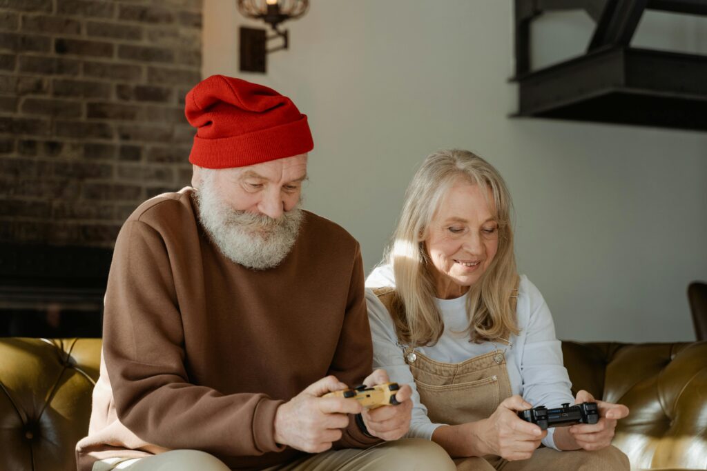 Happy senior couple playing video games at home, having fun together.