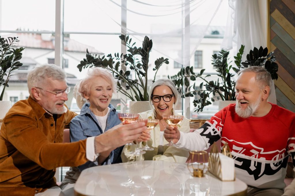 A cheerful group of senior adults enjoying a toast together indoors, celebrating friendship and happiness.